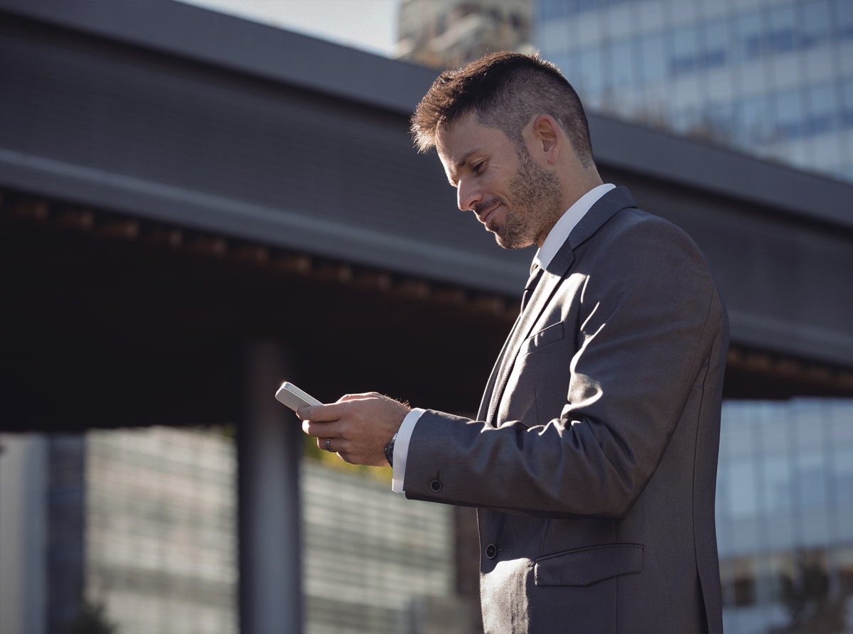 Beginner investor holding a smartphone with stock market app, symbolizing how to start investing with $100.